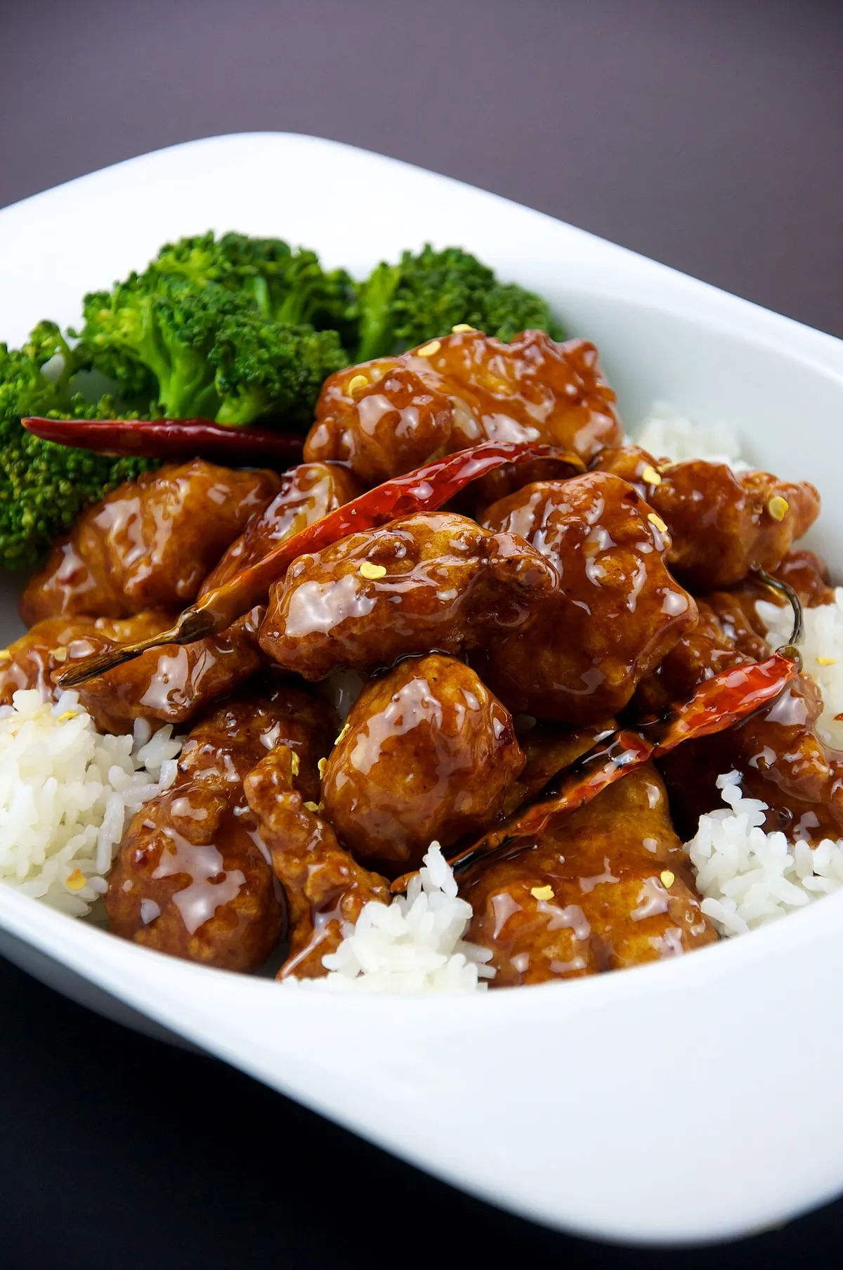General Tso's Chicken on a bed of white rice with broccoli. Photographed in the Oakmore neighborhood of Oakland, California, USA.