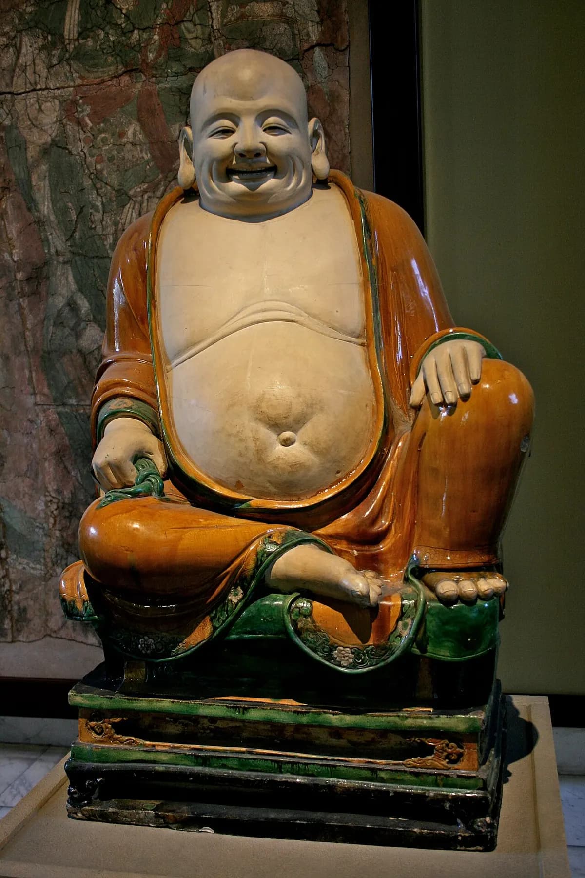 "Stoneware figure of Budai ('laughing budda') under green and ochre glazes. Henan province, Ming dynasty, dated twenthieth year of Chenghus (AD 1486). OA 1937.1